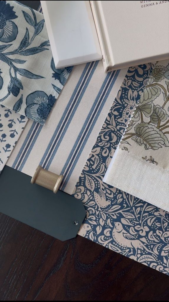 Blue and cream interior design material samples with warm neutral textures and patterns.