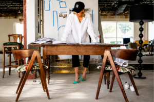 Interior designer reviewing plans during construction, highlighting when to hire an interior designer for new construction to prevent costly changes and improve project outcomes.